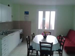 a kitchen with a table with chairs and a red couch at Apartman Pavin, Poljana in Poljana