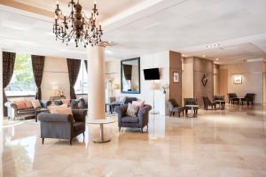 a lobby with chairs and tables and a chandelier at Residhome Paris-Evry in Courcouronnes