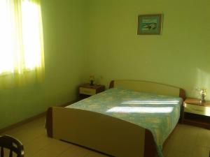 a bedroom with a bed and two tables and a window at Apartman Pavin, Poljana in Poljana