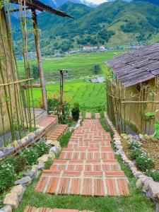 a brick walkway next to a building with a mountain at SaPa Farmer House in Sa Pa