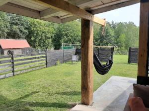 a porch with a hammock in a yard at Domki w Lipowej Dolinie in Huta Górna +35 photos