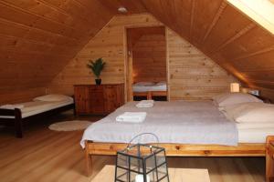 a bedroom with a bed in a wooden cabin at Jurajskie Domki Pod Młyńską Skałą in Zdów