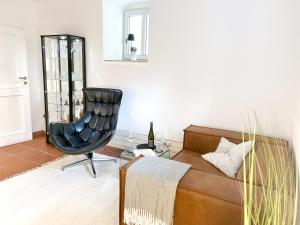 a living room with a couch and a chair at Apartment Elysium am Rosengarten in Bad Elster
