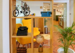 an office with a yellow chair and a desk with a typewriter at Bloom Hotel Koregaon Park in Pune