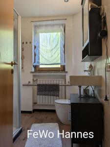 a bathroom with a tub and a sink and a window at Ferienhaus Hilde in Steinwiesen