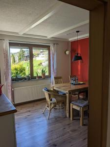 a dining room with a table and chairs and a window at Ferienhaus Hilde in Steinwiesen