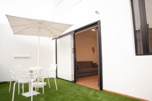 a patio with a table and chairs and an umbrella at Loft Matilde by Grupo Matilde in Las Palmas de Gran Canaria