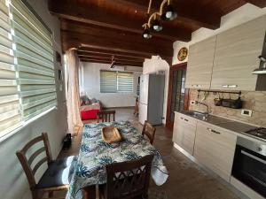 eine Küche mit einem Tisch und eine Küche mit einem Esszimmer in der Unterkunft Villetta Due Palme - vicino GIARDINI NAXOS - in Calatabiano