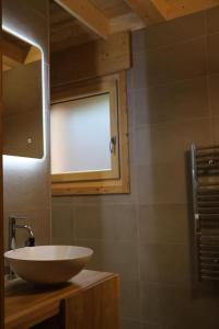 a bathroom with a bowl sink and a window at Chalet au cœur des bois in Larringes