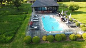 an overhead view of a swimming pool with people in it at Clos Masure hôtel de campagne in Belmesnil