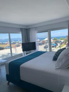 a bedroom with a large bed and a large window at Ocean Blue Suites in Ierissos