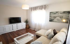 a living room with a couch and a tv at Preciosa casa cerca de la playa de Samil in Vigo