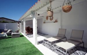a patio with two chairs and a green lawn at Preciosa casa cerca de la playa de Samil in Vigo
