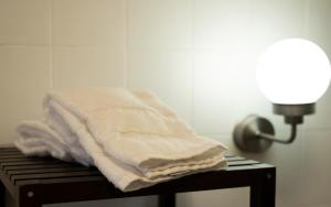 ein Stapel Handtücher auf einem Tisch neben einer Lampe in der Unterkunft Preciosa casa en Vigo cerca de la playa de Samil in Vigo + 37 Fotos