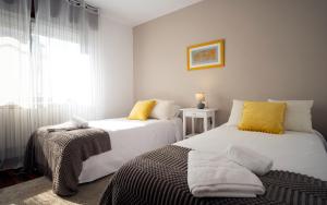 ein Schlafzimmer mit zwei weißen Betten und einem Fenster in der Unterkunft Preciosa casa en Vigo cerca de la playa de Samil in Vigo