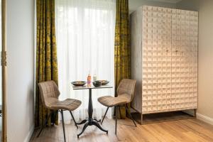 einen Tisch und zwei Stühle in einem Zimmer mit Fenster in der Unterkunft Parkhotel Landau in Landau in der Pfalz