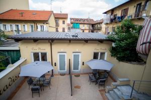 un patio con sedie e ombrelloni di fronte a un edificio di Corte Paradiso a Torino