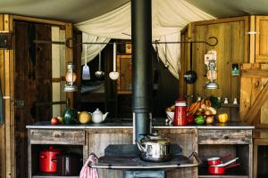 a kitchen with a stove with a pot on a table at Heydon Grove Farm by Feather Down in Heydon +22 photos