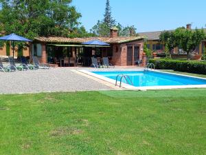 a swimming pool in front of a house at Finca La Pedrera Resort in Capellades