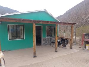a green house with a table and a desk at Cabañas Comarca de la Quebrada in Potrerillos