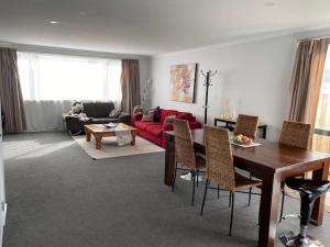ein Wohnzimmer mit einem roten Sofa und einem Tisch in der Unterkunft DELBROOK POINT in Hamilton