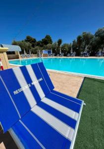 ヴィエステにあるAppartamenti Vacanze Minervinoのスイミングプール前の青いベンチ