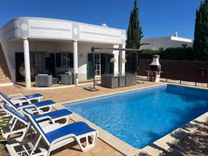 una piscina con sillas y una casa en Spacious 3 bedroom villa with pool en Luz
