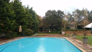 a large blue swimming pool in a yard at Simondium's Country Lodge in Simondium