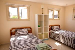 duas camas num quarto com duas janelas em Captivating Lake & Oceanview Getaway House em Meneou