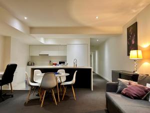 uma cozinha e sala de estar com mesa e cadeiras em ReadySet Apartments on Little Collins em Melbourne