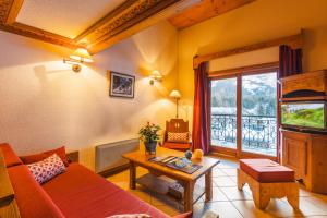 - un salon avec un canapé et une table dans l'établissement Lagrange Vacances Le Cristal d'Argentière, à Chamonix-Mont-Blanc