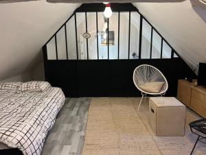 een slaapkamer met een bed en een stoel bij LE LOFT DU DOUBS in Besançon