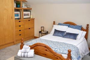 1 dormitorio con cama de madera y vestidor en 'Maigue View' by the River en Croom