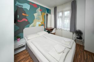 ein Schlafzimmer mit einem weißen Bett und einer farbenfrohen Wand in der Unterkunft Great Polonia Dwarf Wrocław in Breslau