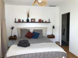 a bedroom with a large white bed with pillows at Villa de la Tour in Bellegarde