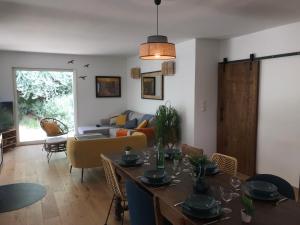 a living room with a table and a couch at Villa de la Tour in Bellegarde