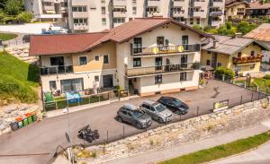 two cars parked in a parking lot in front of a building at Alpha Apartments in Schwarzach im Pongau