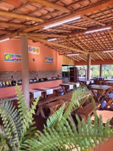 a restaurant with wooden tables and chairs and plants at Pousada Canyons in Capitólio