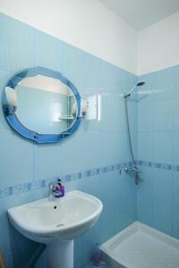 een badkamer met een wastafel en een spiegel bij Vila Suljo in Ksamil