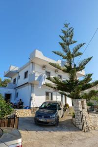 um carro estacionado em frente a um edifício com uma árvore de Natal em Vila Suljo em Ksamil