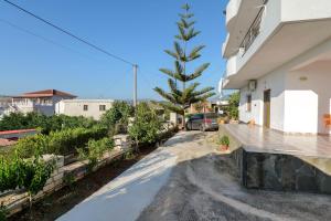 uma casa com uma árvore ao lado de uma rua em Vila Suljo em Ksamil