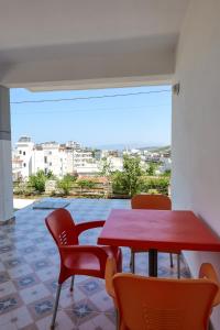 uma mesa e cadeiras vermelhas em uma sala com vista em Vila Suljo em Ksamil