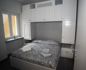 una camera da letto con armadi bianchi e un letto con due asciugamani di Corte Paradiso a Torino