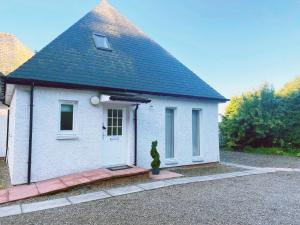 Une petite maison blanche avec un cactus en face dans l'établissement Castlehill, à Dundee