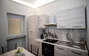 a kitchen with white cabinets and a sink and a table at Corte Paradiso in Turin