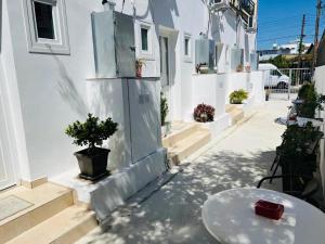 a white building with a table and a potted plant at Larnaca - Studio - Sleeps 4 - Garden - Parking in Larnaca
