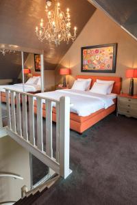 a large bedroom with two beds and a chandelier at Landhuishotel De Bloemenbeek in De Lutte