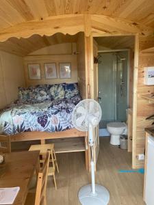 sypialnia z łóżkiem i wentylatorem w kabinie w obiekcie La Ferme de Roulotte de Sandrine w mieście Carentoir