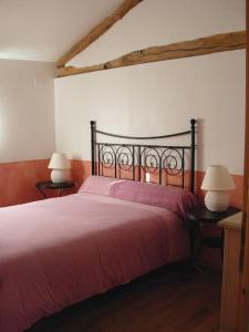 a bedroom with a red bed with two lamps at Grand gîte pour 18 personnes dans la campagne tarnaise in Andouque