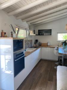 a kitchen with white cabinets and a blue oven at Villacielgacha in São Brás de Alportel